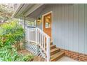 Charming front entrance featuring a wooden door, gray siding, and inviting landscaping at 2916 Rue Sans Famille, Raleigh, NC 27607