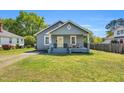 Charming one-story home with a cozy front porch, swing, and well-manicured lawn in a quiet neighborhood at 303 E J St, Erwin, NC 28339