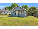 Charming one-story home with a cozy front porch, swing, and well-manicured lawn in a residential area at 303 E J St, Erwin, NC 28339