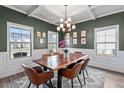 Elegant dining room with coffered ceilings, wainscoting, and modern chandelier at 34 Tea Olive Ct, Clayton, NC 27520