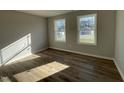 Bright bedroom featuring luxury vinyl flooring and two windows for natural light at 37 Heatherglenn Cir, Princeton, NC 27569