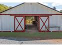 Barn with large sliding doors opening to the stables with wooden railings at 3787 Pleasant Hill Church, Siler City, NC 27344