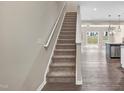 Carpeted staircase leading to the upper level, with modern wood-look flooring and an open-concept design at 41 Willow Green Dr, Clayton, NC 27527