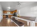 Spacious dining area featuring a long table with bench seating, complemented by ample natural light and kitchen views at 413 Bayles Rd, Lillington, NC 27546