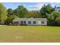Charming home featuring a well-maintained lawn and inviting front porch, ideal for relaxing and enjoying the outdoors at 413 Bayles Rd, Lillington, NC 27546