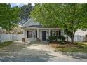 Charming home featuring a covered porch, black shutters and a well-maintained landscaped yard at 4414 Nightfall Ct, Durham, NC 27713