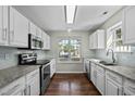 Bright kitchen with white cabinets, granite countertops, stainless steel appliances, and a window over the sink at 4414 Nightfall Ct, Durham, NC 27713