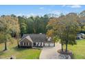 Sprawling home showcases a spacious lot with mature trees, a long driveway, and an attached two-car garage at 460 Mann Rd, Coats, NC 27521