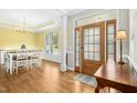 Bright dining room featuring hardwood floors, a modern chandelier, and natural light from the windows at 460 Mann Rd, Coats, NC 27521