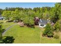 Charming home boasts a sprawling lawn, mature trees, and a serene, private setting at 5212 Theys Rd, Raleigh, NC 27606