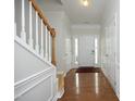 Bright foyer with hardwood floors, white wainscoting, and a staircase leading to the upper level at 5403 Bayside Ct, Raleigh, NC 27613