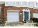Home exterior featuring a brick facade, a single-car garage, and a green front door with decorative trim at 5403 Bayside Ct, Raleigh, NC 27613