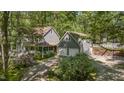 Two-story home featuring a detached two-car garage and a brick patio area, all nestled in a wooded setting at 6105 Splitrock Trl, Apex, NC 27539