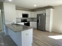 The kitchen offers stainless appliances, granite counters, white cabinets and hardwood floors at 70 Pate Landing Dr, Selma, NC 27576