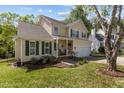 Beautiful exterior with a manicured lawn, green shutters, and a cozy front porch with rocking chairs at 703 Midsummer Ln, Apex, NC 27502