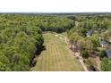 Scenic aerial view of a lush golf course surrounded by dense woodlands and clear blue skies at 720 Raymond Dr, Clayton, NC 27527