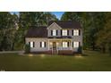 Charming home illuminated at dusk, featuring a classic design and inviting front porch at 720 Raymond Dr, Clayton, NC 27527