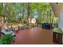 View of a back deck, with a metal railing, BBQ, bench, and landscaping at 730 N Harrison Ave, Cary, NC 27513