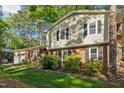View of the 2-story home's exterior, featuring a brick facade, black shutters and lush landscaping at 730 N Harrison Ave, Cary, NC 27513