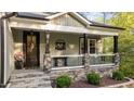Inviting front porch with stone accents, decorative railing, and charming entry door at 775 Sagamore Dr, Louisburg, NC 27549