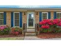 Close-up of the front door, with glass, sidelights, blue shutters and vibrant flowers at 801 Silver Leaf Pl, Raleigh, NC 27609