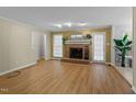 Inviting living room featuring a brick fireplace, hardwood flooring, and ample natural light streaming through the windows at 801 Silver Leaf Pl, Raleigh, NC 27609