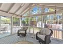 Screened-in porch featuring cozy seating, vaulted ceiling, and bright views of the outdoor landscape at 8721 Attingham Dr, Raleigh, NC 27615