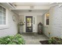 Charming front porch with brick walls, decorative plants, and a stylish front door at 1001 Manchester Dr, Raleigh, NC 27609