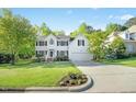 Charming two-story white home with a well-maintained lawn and driveway leading to the attached garage at 102 Cockleshell Ct, Cary, NC 27513
