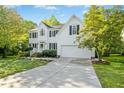 Inviting two-story residence with a spacious driveway leading to the attached garage, nestled among mature trees at 102 Cockleshell Ct, Cary, NC 27513