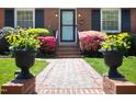 Inviting brick pathway leading to the home with well-placed potted plants and manicured bushes at 1109 Huntington Ave, Durham, NC 27707