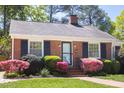 Well-maintained brick home with a neat lawn and colorful shrubbery enhancing curb appeal at 1109 Huntington Ave, Durham, NC 27707