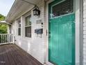Close-up of a bright teal front door with a classic mailbox, stylish light fixture and house number at 1116 Holburn Pl, Raleigh, NC 27610