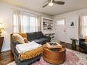 Cozy living room with a comfortable sofa, stylish round wood table, ceiling fan, and a built-in bookshelf at 1116 Holburn Pl, Raleigh, NC 27610