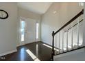 Inviting foyer with hardwood floors, staircase with white spindles, and natural light from the front door at 120 Putters Ct, Durham, NC 27703