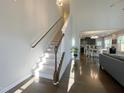 Hallway featuring hardwood floors, stairway, and an open view into the dining and kitchen areas at 120 Putters Ct, Durham, NC 27703
