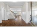 Bright foyer features hardwood flooring, white wainscoting, and stairway leading to upper level at 1203 Great Egret Way, Durham, NC 27713