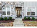Inviting front entrance of home featuring decorative stone, manicured landscaping, and a modern front door at 1203 Great Egret Way, Durham, NC 27713