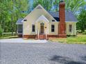 Inviting home exterior with a brick foundation, covered porch, and attractive landscaping at 1208 Goodwin Rd, Apex, NC 27523