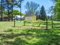 Scenic property featuring a storage shed, grape vines, and lush greenery at 1208 Goodwin Rd, Apex, NC 27523
