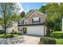 Charming two-story home featuring a 2-car garage, manicured lawn, and covered front porch at 12433 N Exeter Way, Durham, NC 27703