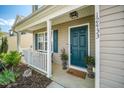 Inviting front porch features a craftsman-style door, and decorative plants at 12433 N Exeter Way, Durham, NC 27703