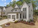 Elegant two-story home with two car garage, landscaped yard and a painted white brick and gray trim exterior at 127 Sanderway Dr, Chapel Hill, NC 27516
