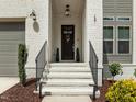 Charming front entrance with black door, white painted steps, and black railing leading into the home at 127 Sanderway Dr, Chapel Hill, NC 27516
