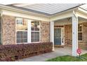 Charming home entrance with a stone facade, white columns, and a well-maintained landscape at 1307 Seattle Slew Ln, Cary, NC 27519