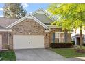 Brick house featuring a two-car garage and well-manicured lawn at 1307 Seattle Slew Ln, Cary, NC 27519