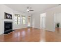 Bright living room features a fireplace, hardwood floors, a ceiling fan, and access to a sunroom at 1307 Seattle Slew Ln, Cary, NC 27519