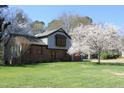 Lovely home with mature flowering tree, brick, siding, and well-kept lawn on a sunny day at 1400 Rainwood Ln, Raleigh, NC 27615