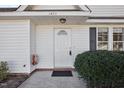 Close-up of the home's entrance with a white front door, brick trim, and manicured bushes at 1432 E Stonemason Dr, Fuquay Varina, NC 27526