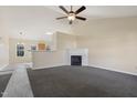 Bright living room featuring a fireplace, ceiling fan, and neutral-toned walls and carpeting at 1432 E Stonemason Dr, Fuquay Varina, NC 27526